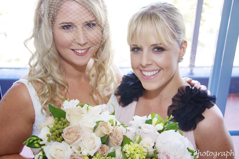 Bride and bridesmaid smiling up at camera - wedding photography sydney
